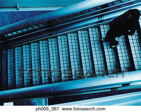 Stock Photo - Woman walking down staircase, elevated view. Fotosearch