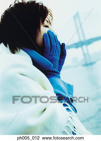 Stock Image - Young woman at waterfront, bridge in background. Fotosearch