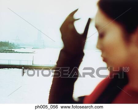 Stock Photograph - Young woman at waterfront, close up. Fotosearch