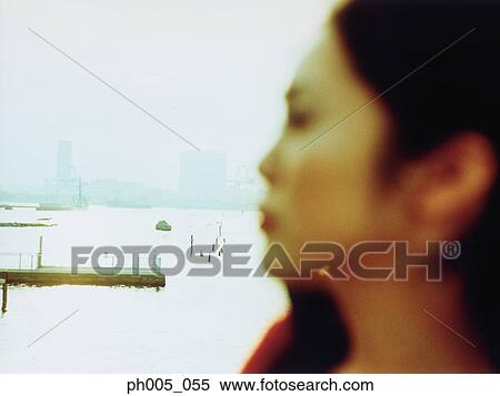 Young woman at waterfront, close up View Large Photo Image Stock Photography - Young woman at waterfront, close up. Fotosearch