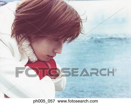 Stock Photo - Young woman at waterfront, portrait. Fotosearch