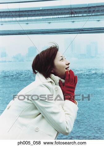 Stock Photo - Young woman at waterfront, portrait. Fotosearch