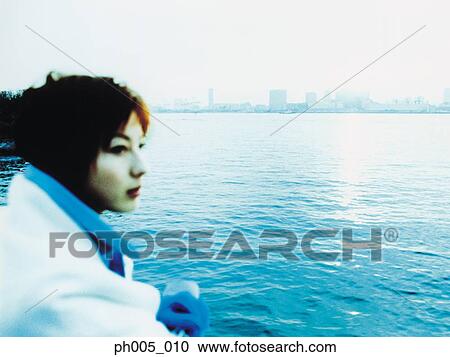 Stock Image - Young woman at waterfront . Fotosearch