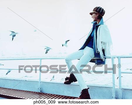 Young woman on ferry deck, Tokyo city in background, a flock of seagulls View Large Photo Image Stock Photo - Young woman on ferry deck, Tokyo city in background, a flock of seagulls. Fotosearch