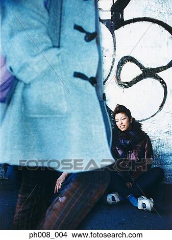 Picture - A passer-by, woman sitting on the ground. Fotosearch