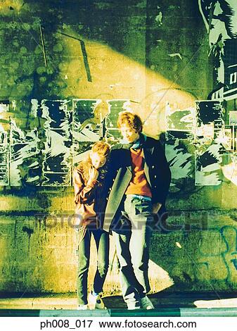 Couple leaning against wall View Large Photo Image Stock Photo - Couple leaning against wall. Fotosearch