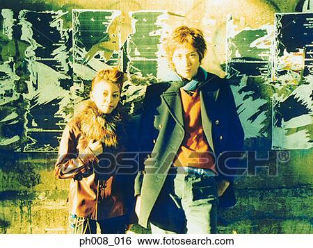 Couple leaning against wall View Large Photo Image Stock Photograph - Couple leaning against wall. Fotosearch