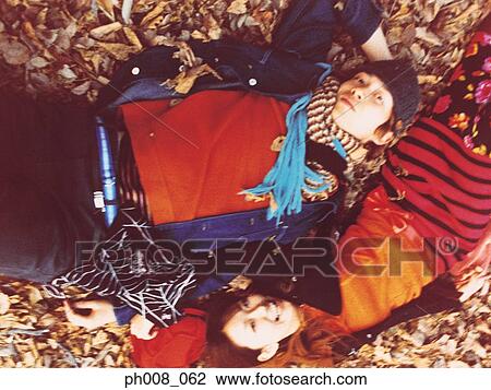 Couple lying on dried leaves covered ground View Large Photo Image Stock Image - Couple lying on dried leaves covered ground. Fotosearch