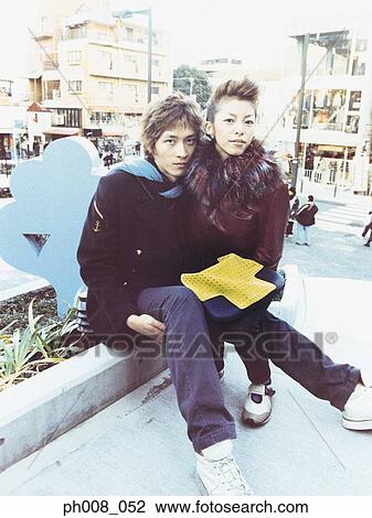 Stock Image - Couple sitting in a park. Fotosearch
