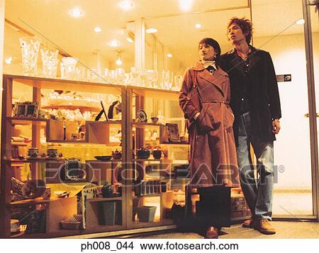 Couple standing outside a shop View Large Photo Image Picture - Couple standing outside a shop. Fotosearch