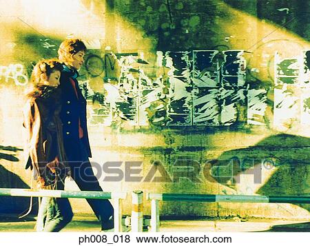 Couple walking on the street View Large Photo Image Stock Photo - Couple walking on the street. Fotosearch