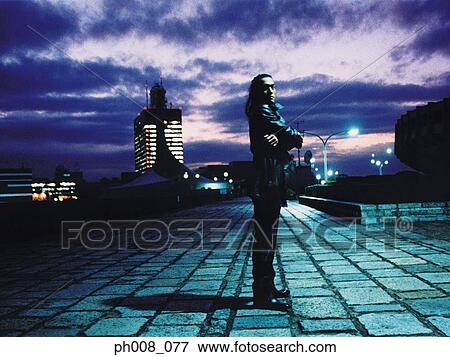Silhouetted man standing in a park at sunset View Large Photo Image Stock Photo - Silhouetted man standing in a park at sunset. Fotosearch