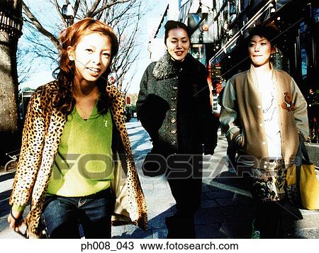 Three young women walking on the street View Large Photo Image Stock Image - Three young women walking on the street. Fotosearch