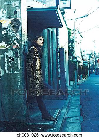 Woman leaning against wall View Large Photo Image Stock Photograph - Woman leaning against wall. Fotosearch