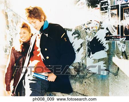 Young couple leaning against vandalized wall View Large Photo Image Stock Photo - Young couple leaning against vandalized wall. Fotosearch