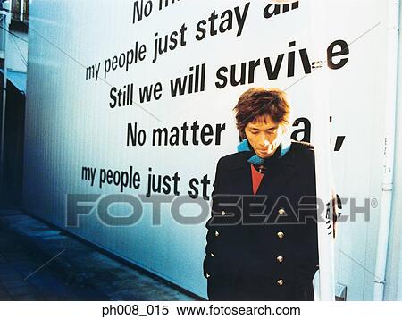 Young man leaning against wall View Large Photo Image Stock Photography - Young man leaning against wall. Fotosearch