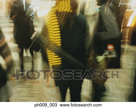 Stock Image - Commuters walking in subway passageway (blurred motion) . Fotosearch