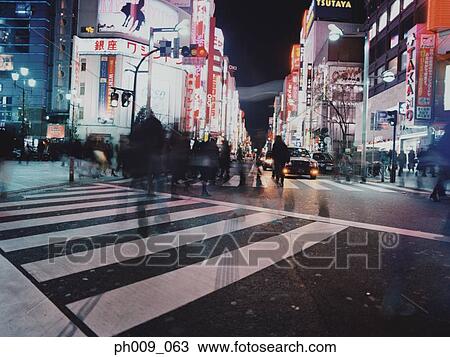Stock Image - Pedestrians crossing street, night, Shibuya-ku, Tokyo, Japan. Fotosearch