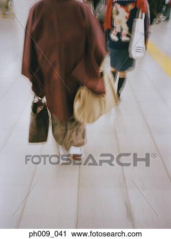 Stock Image - Woman in kimono walking (blurred motion). Fotosearch