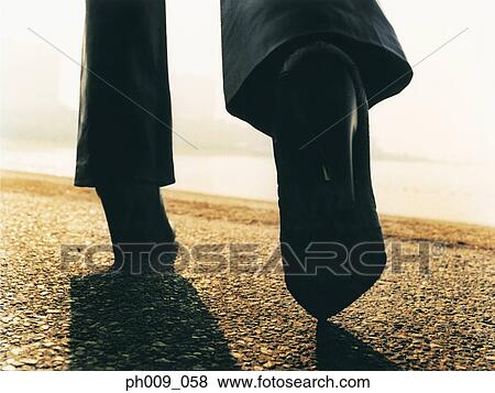 Woman walking on pavement View Large Photo Image Stock Photo - Woman walking on pavement. Fotosearch