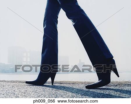 Woman walking on pavement View Large Photo Image Stock Photograph - Woman walking on pavement. Fotosearch