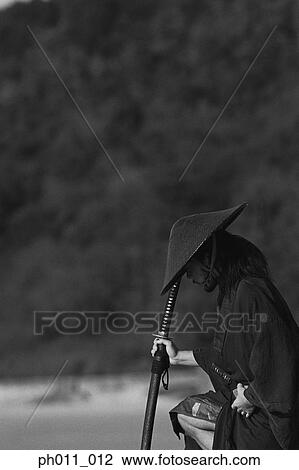 Stock Image - Samurai warrior holding a sword at the seaside . Fotosearch