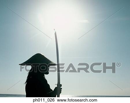 Samurai warrior holding a sword View Large Photo Image Stock Photograph - Samurai warrior holding a sword. Fotosearch