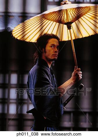 Samurai warrior holding an umbrella View Large Photo Image Stock Photo - Samurai warrior holding an umbrella. Fotosearch