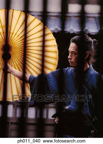 Stock Image - Samurai warrior opening an umbrella. Fotosearch