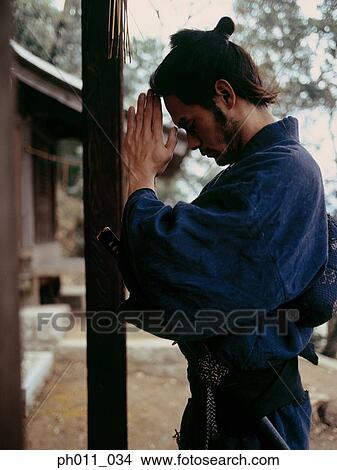 Picture - Samurai warrior praying at a shrine . Fotosearch