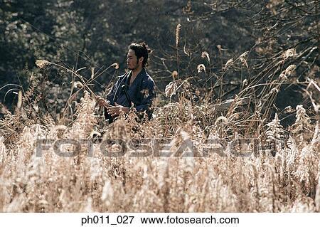 Samurai warrior standing in the middle of a field View Large Photo Image Stock Photo - Samurai warrior standing in the middle of a field. Fotosearch
