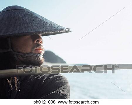 Samurai warrior holding a sword View Large Photo Image Stock Photo - Samurai warrior holding a sword. Fotosearch