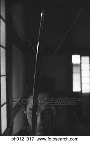 Samurai warrior holding a sword View Large Photo Image Stock Photo - Samurai warrior holding a sword. Fotosearch