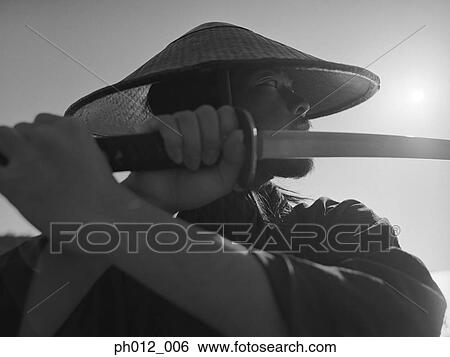 Samurai warrior holding a sword View Large Photo Image Stock Photograph - Samurai warrior holding a sword. Fotosearch