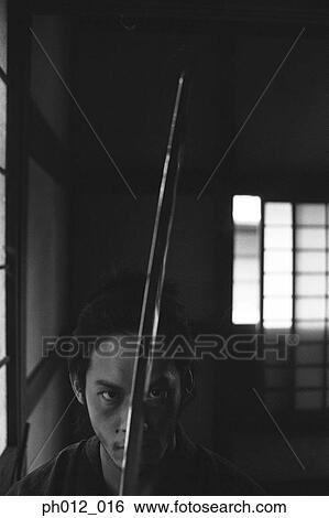 Samurai warrior holding a sword View Large Photo Image Stock Photograph - Samurai warrior holding a sword. Fotosearch
