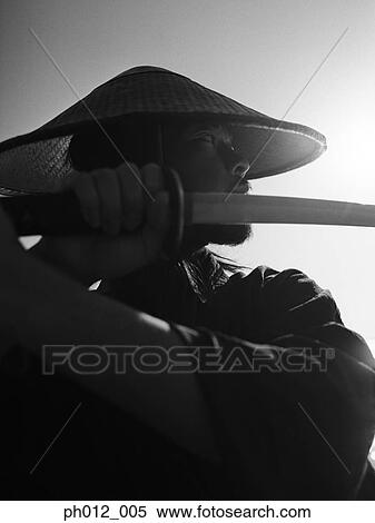 Samurai warrior holding a sword View Large Photo Image Stock Photography - Samurai warrior holding a sword. Fotosearch