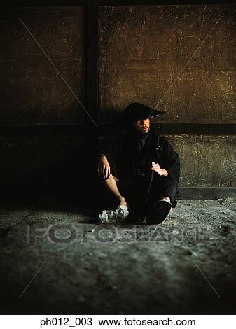 Stock Image - Samurai warrior sitting on the floor. Fotosearch