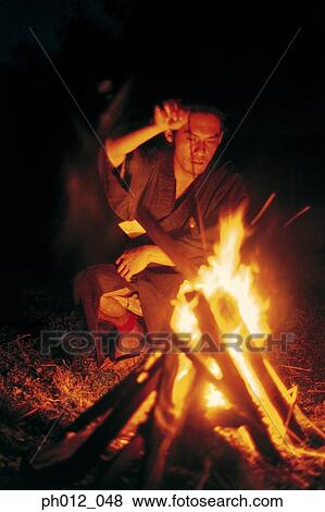 Samurai warrior squatting in front of burning fire View Large Photo Image Stock Photo - Samurai warrior squatting in front of burning fire. Fotosearch