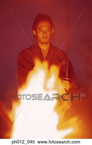 Samurai warrior standing in front of burning fire View Large Photo Image Stock Photography - Samurai warrior standing in front of burning fire. Fotosearch
