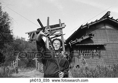 Stock Photography - Samurai warrior drawing out a sword. Fotosearch
