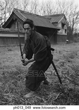 Samurai warrior holding a sword View Large Photo Image Stock Photo - Samurai warrior holding a sword. Fotosearch