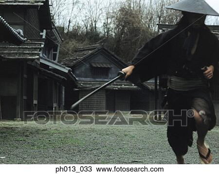 Stock Image - Samurai warrior running with a sword in his hand. Fotosearch