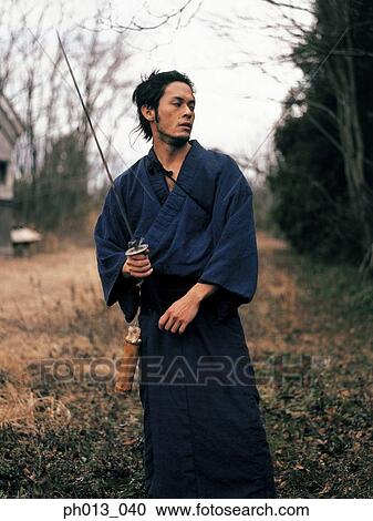 Samurai warrior standing with a sword in his hand View Large Photo Image Stock Image - Samurai warrior standing with a sword in his hand. Fotosearch