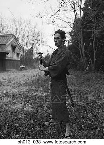 Stock Photo - Samurai warrior standing with a sword in his hand. Fotosearch