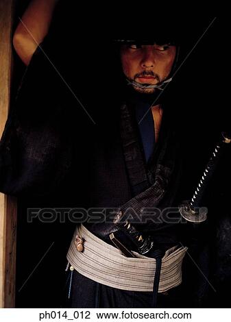 Stock Image - Portrait of a Samurai warrior in a room. Fotosearch