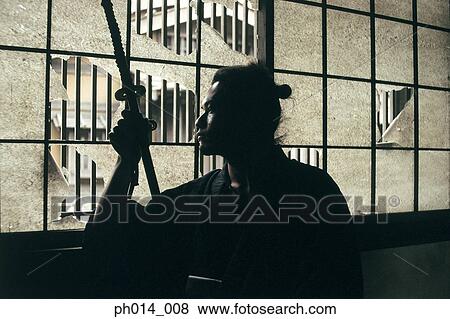 Samurai warrior holding a sword View Large Photo Image Stock Photo - Samurai warrior holding a sword. Fotosearch