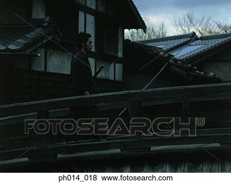 Samurai warrior walking on a bridge View Large Photo Image Stock Photo - Samurai warrior walking on a bridge. Fotosearch