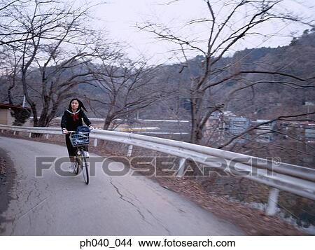 School girl cycling along the road View Large Photo Image Picture - School girl cycling along the road. Fotosearch