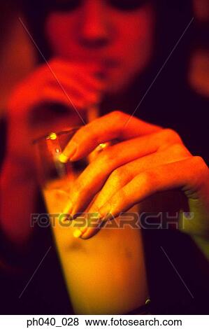 Stock Photo - School girl drinking a glass of juice with a straw. Fotosearch