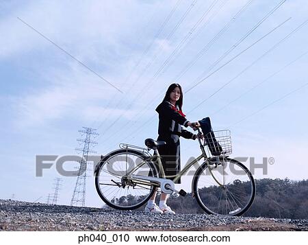 School girl holding a bicycle View Large Photo Image Stock Image - School girl holding a bicycle. Fotosearch